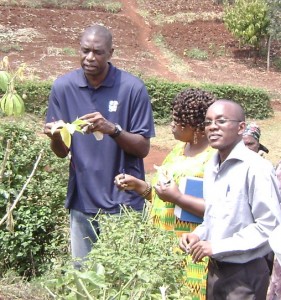 Mutombo (pictured at far left), the global ambassador of the NBA, represented Cindy McCain at a visit to 3rd year scholar Michael Murigi’s (pictured at right) cassava project in Maragua Division.